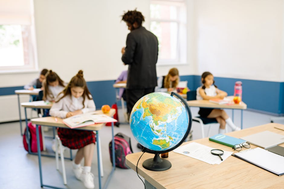A classroom scene with students studying geography, highlighted by a prominent globe on the teacher's desk.
